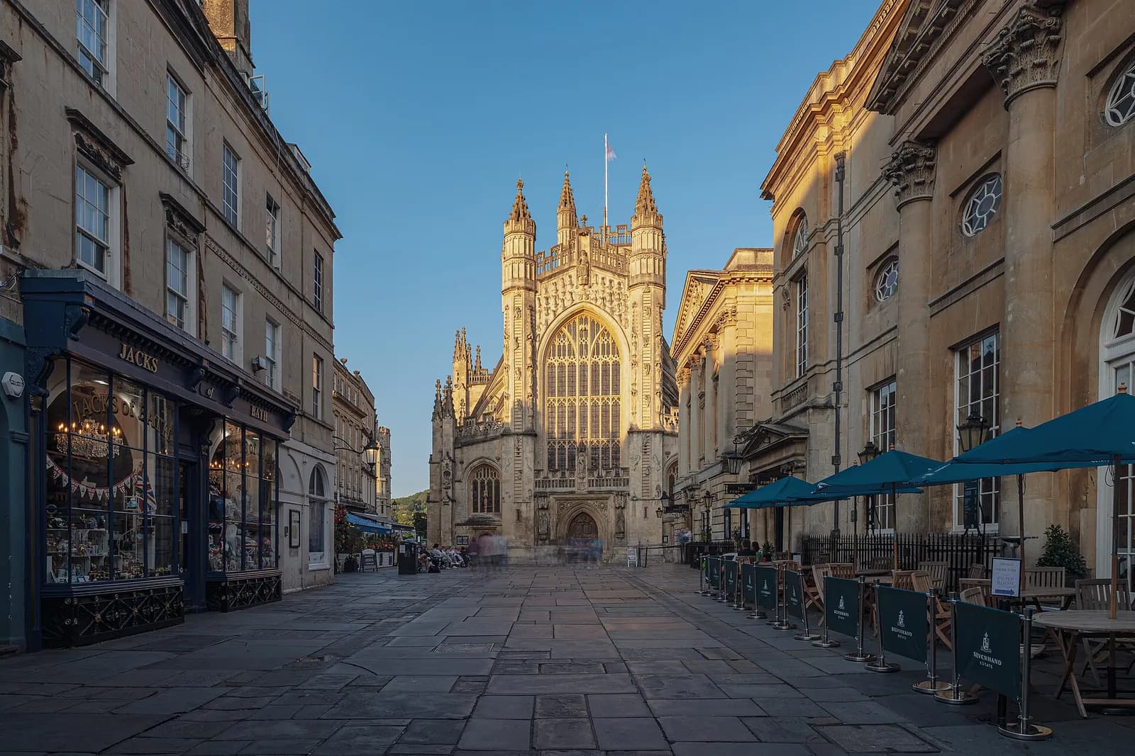 Bath Abbey's west front at the end of a stone-paved street, in afternoon light