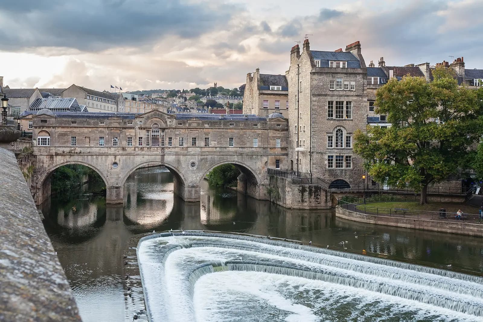 Pulteney Bridge's shop-lined arches over the River Avon, above the curved weir