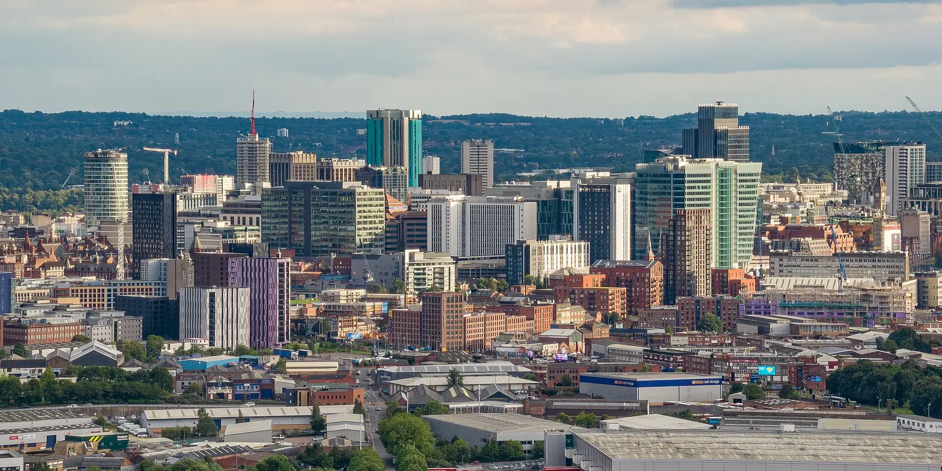 Birmingham's city-centre tower blocks seen from the north, with green hills on the horizon
