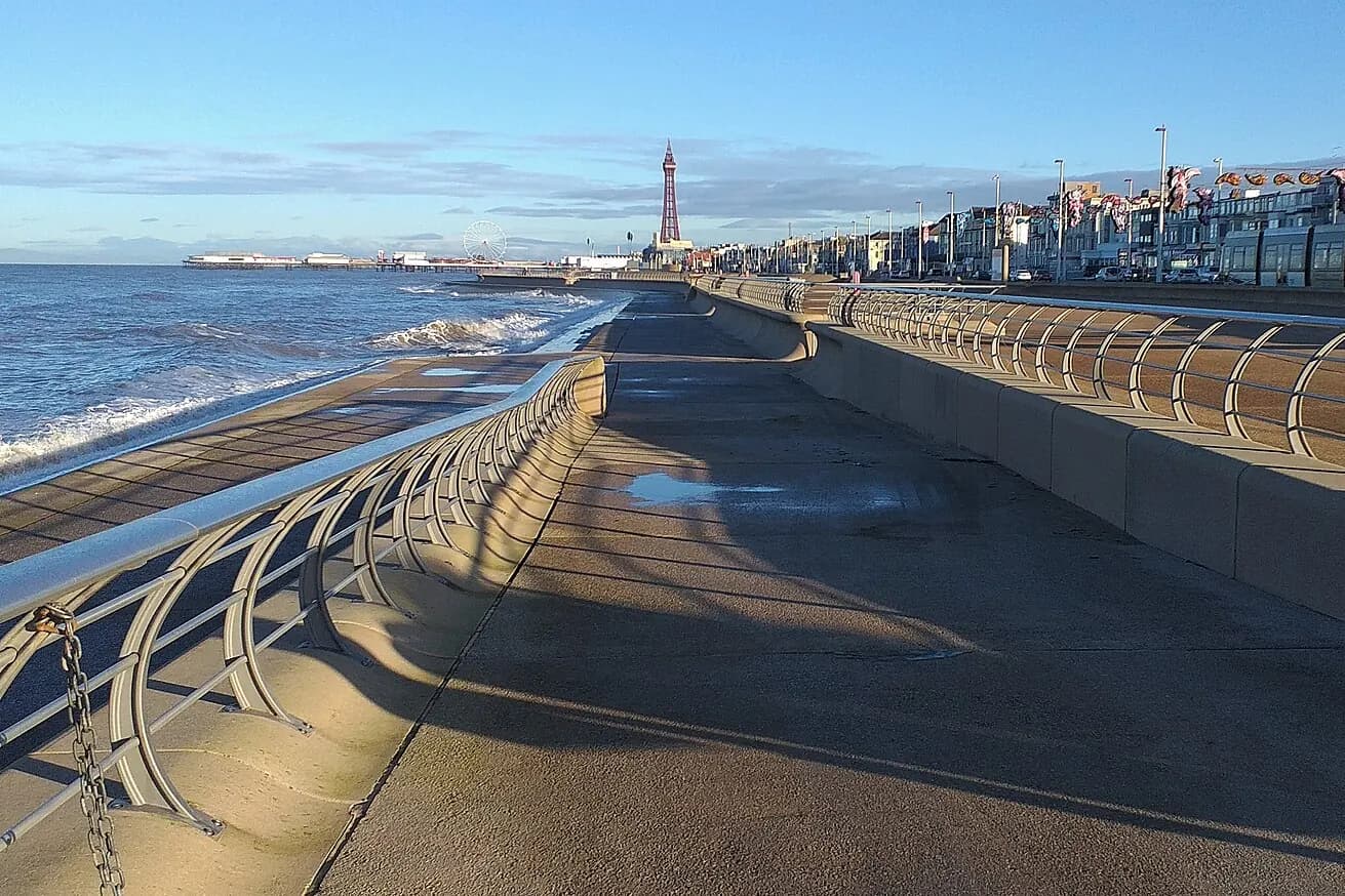 The promenade sea wall curving north towards the Tower on a clear day