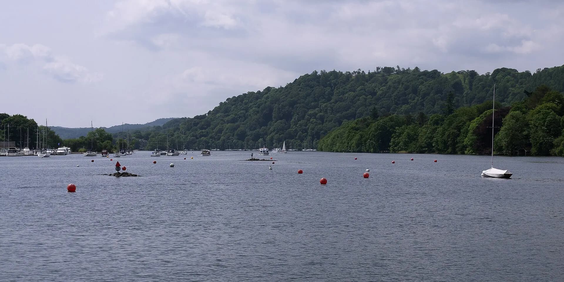 Boats moored on Lake Windermere near Bowness, with wooded hills along the far shore