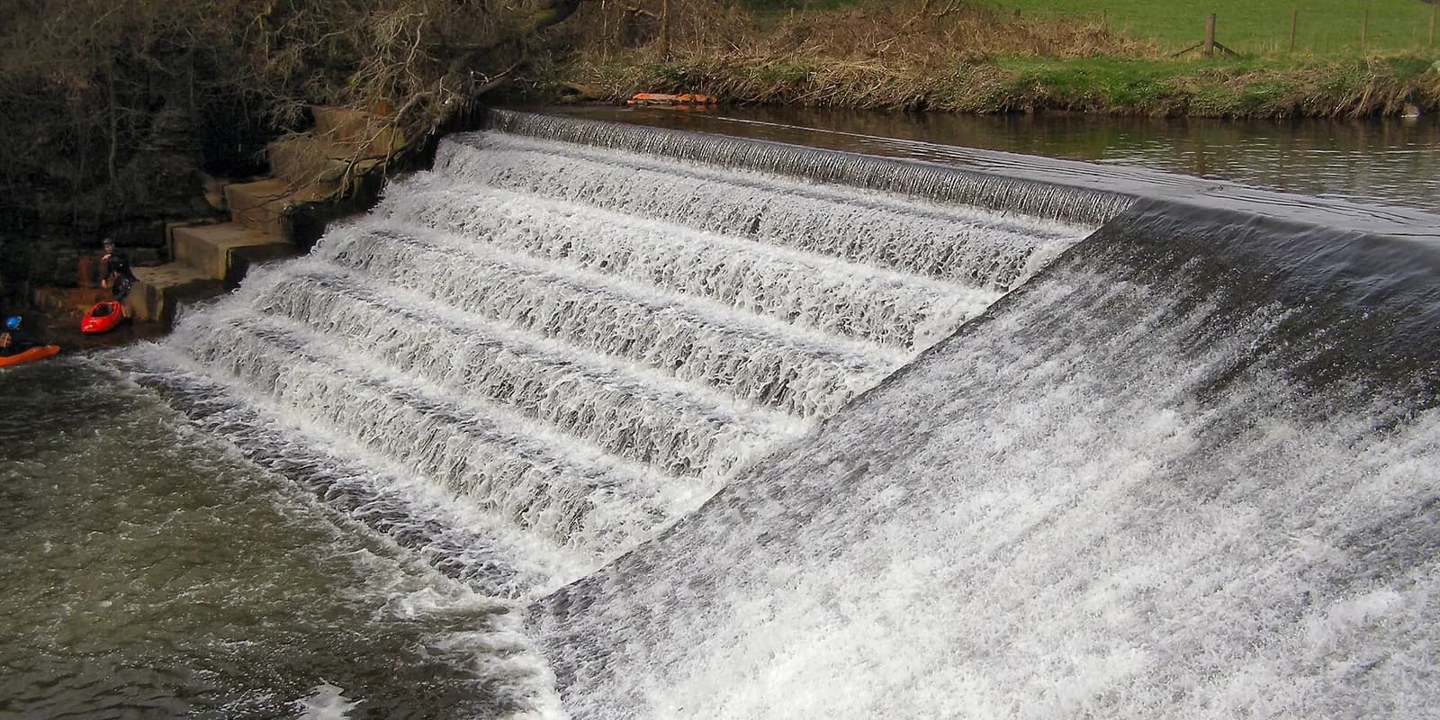 Water pouring over the stepped weir on the River Irwell at Burrs Country Park