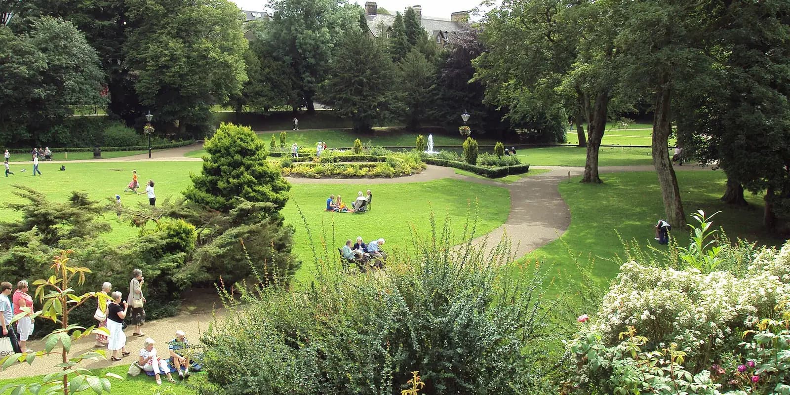 Lawns, flower beds and trees in the Pavilion Gardens in Buxton on a sunny day