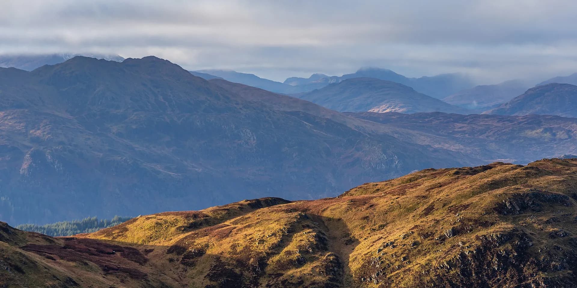 The ridge of Ben Ledi, with golden moorland in front and blue mountains beyond