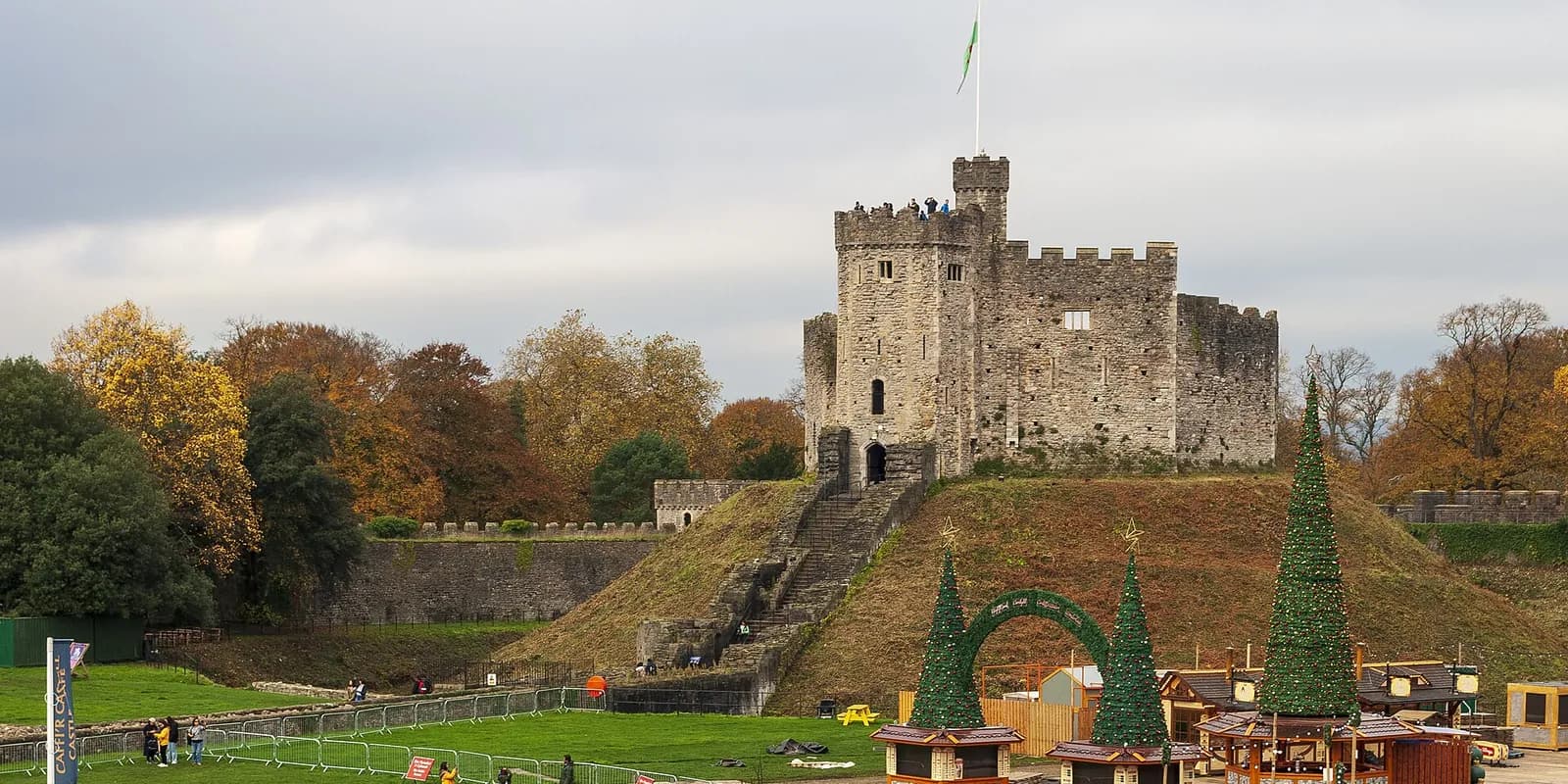 The stone keep of Cardiff Castle on its grassy mound, among autumn trees