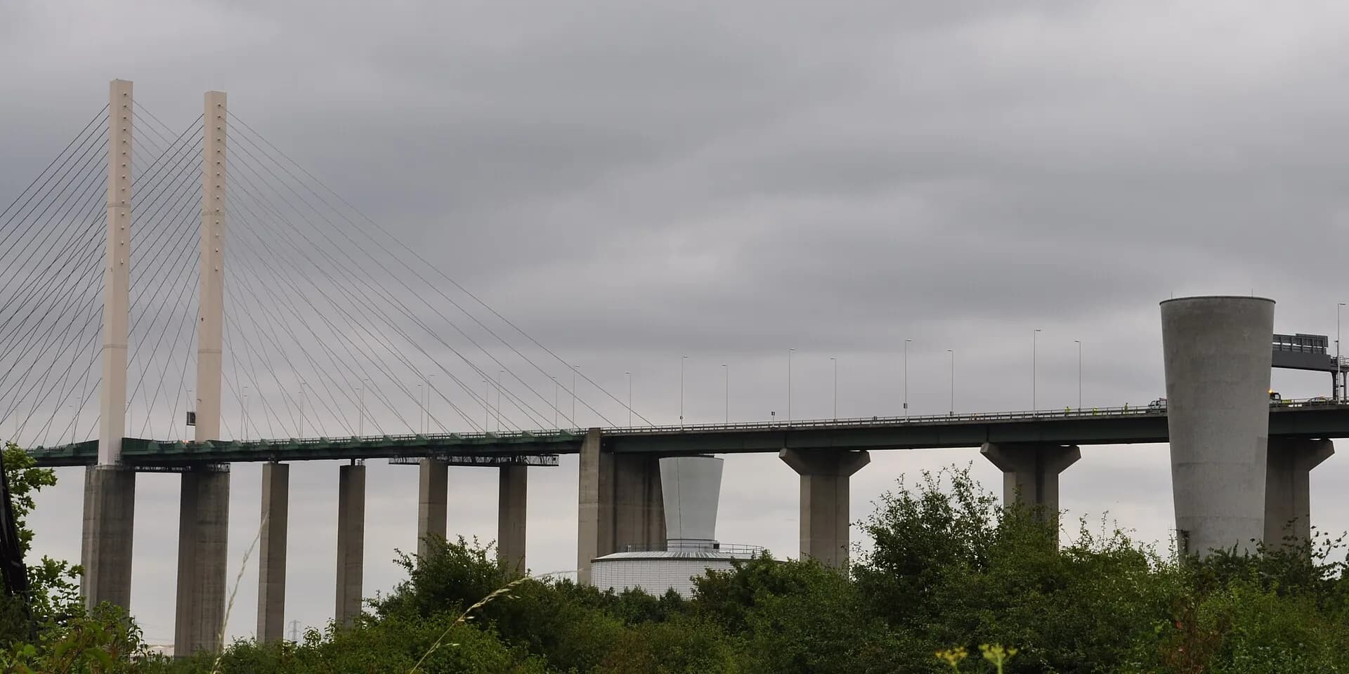 The towers and long deck of the Queen Elizabeth II Bridge at the Dartford Crossing, under a grey sky