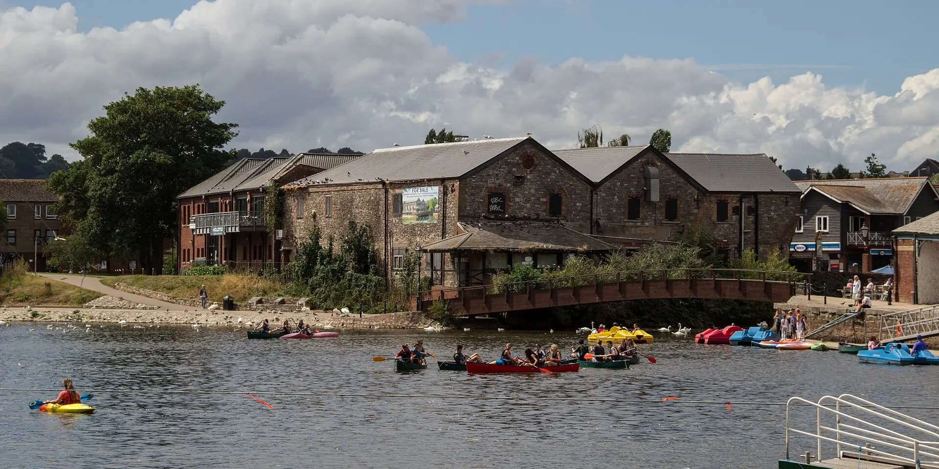 Exeter Quay's old stone warehouses beside the River Exe, with canoes on the water