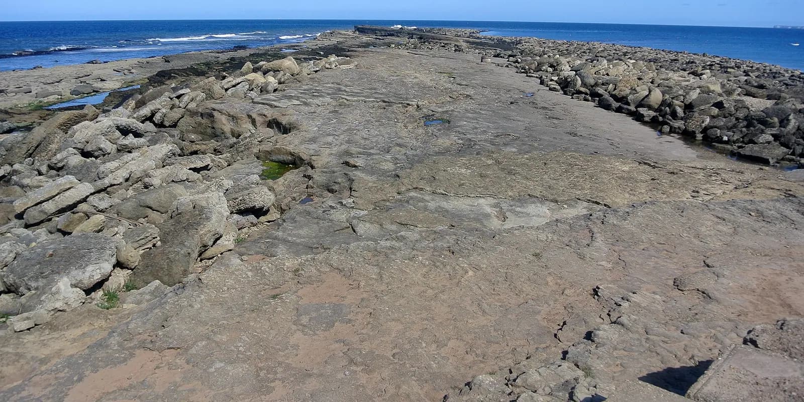 The rocky ledges of Filey Brigg stretching out into a blue sea
