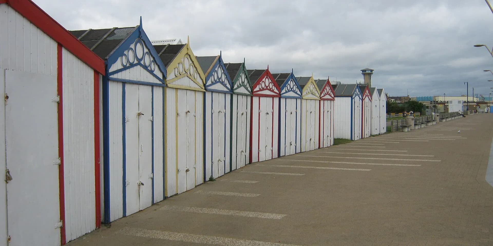A long row of painted beach huts with red, blue and yellow trim along Great Yarmouth's seafront