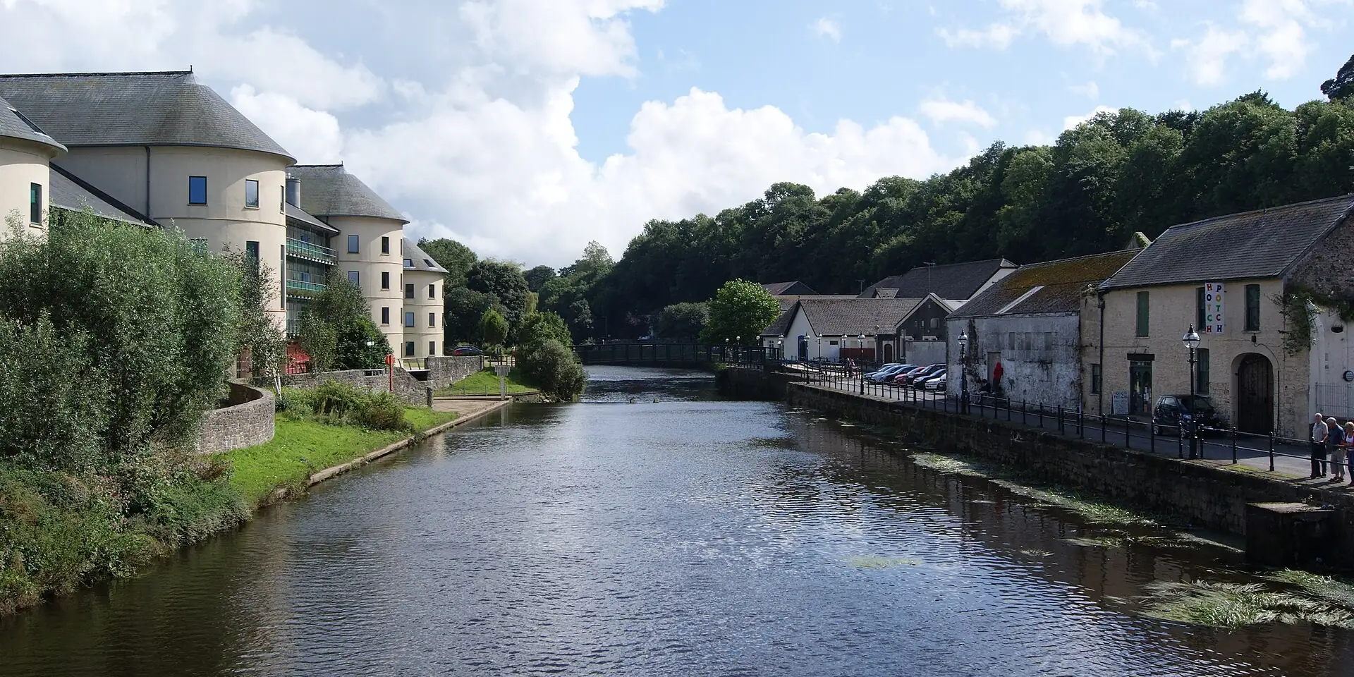 The River Cleddau flowing through Haverfordwest between old stone buildings and trees