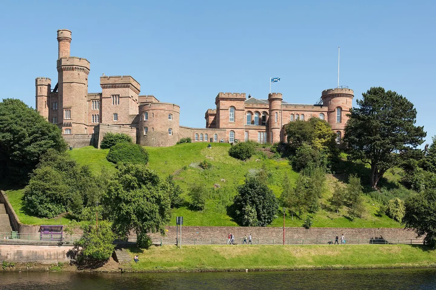 Inverness Castle's red sandstone towers on a green hill above the River Ness