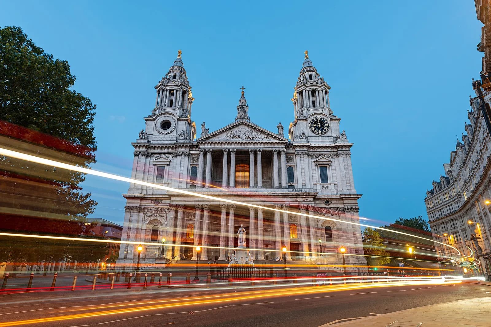 The west front of St Paul's Cathedral at dusk, with light trails from passing traffic