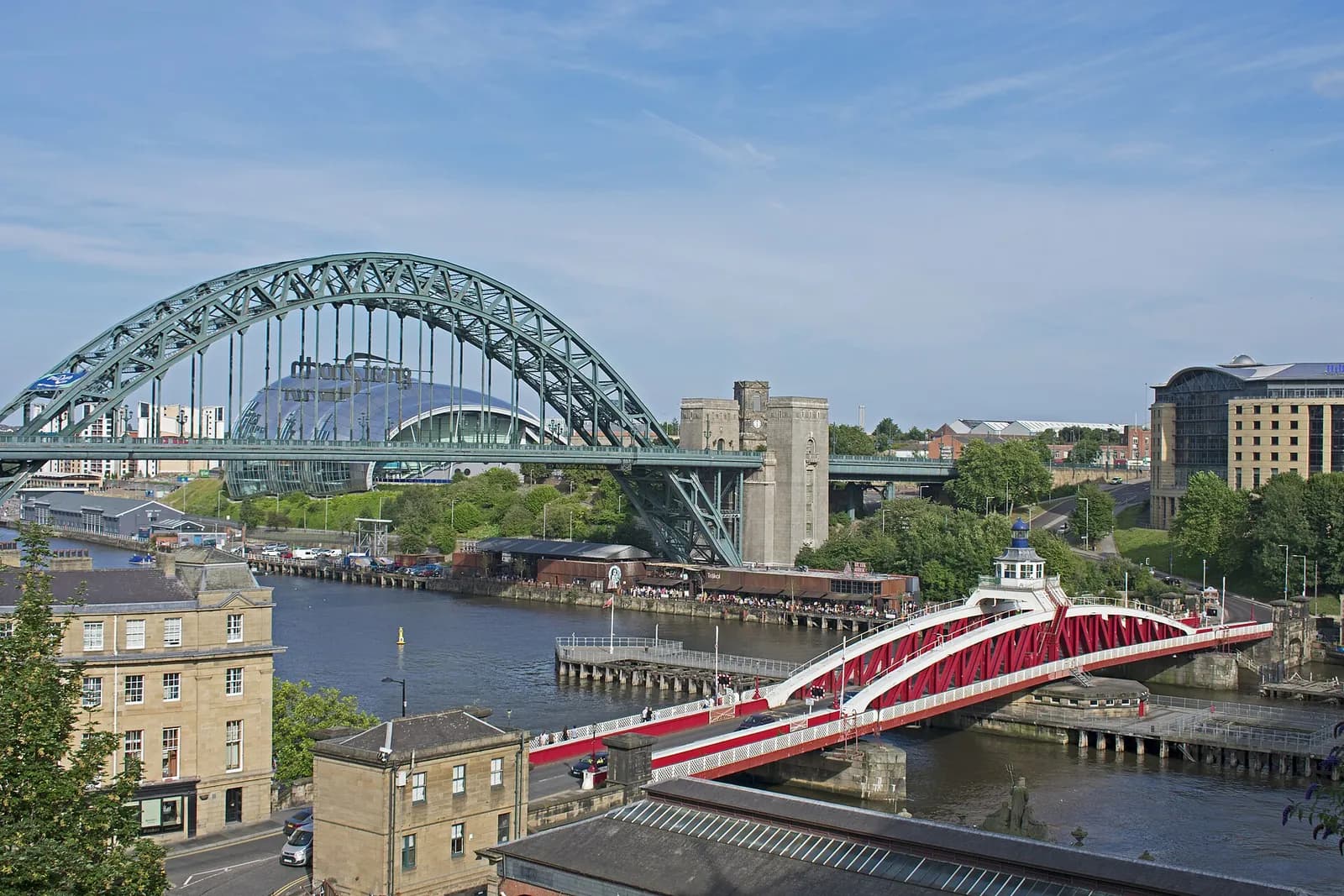 The Tyne Bridge and the red-and-white Swing Bridge over the river at Newcastle, seen from above