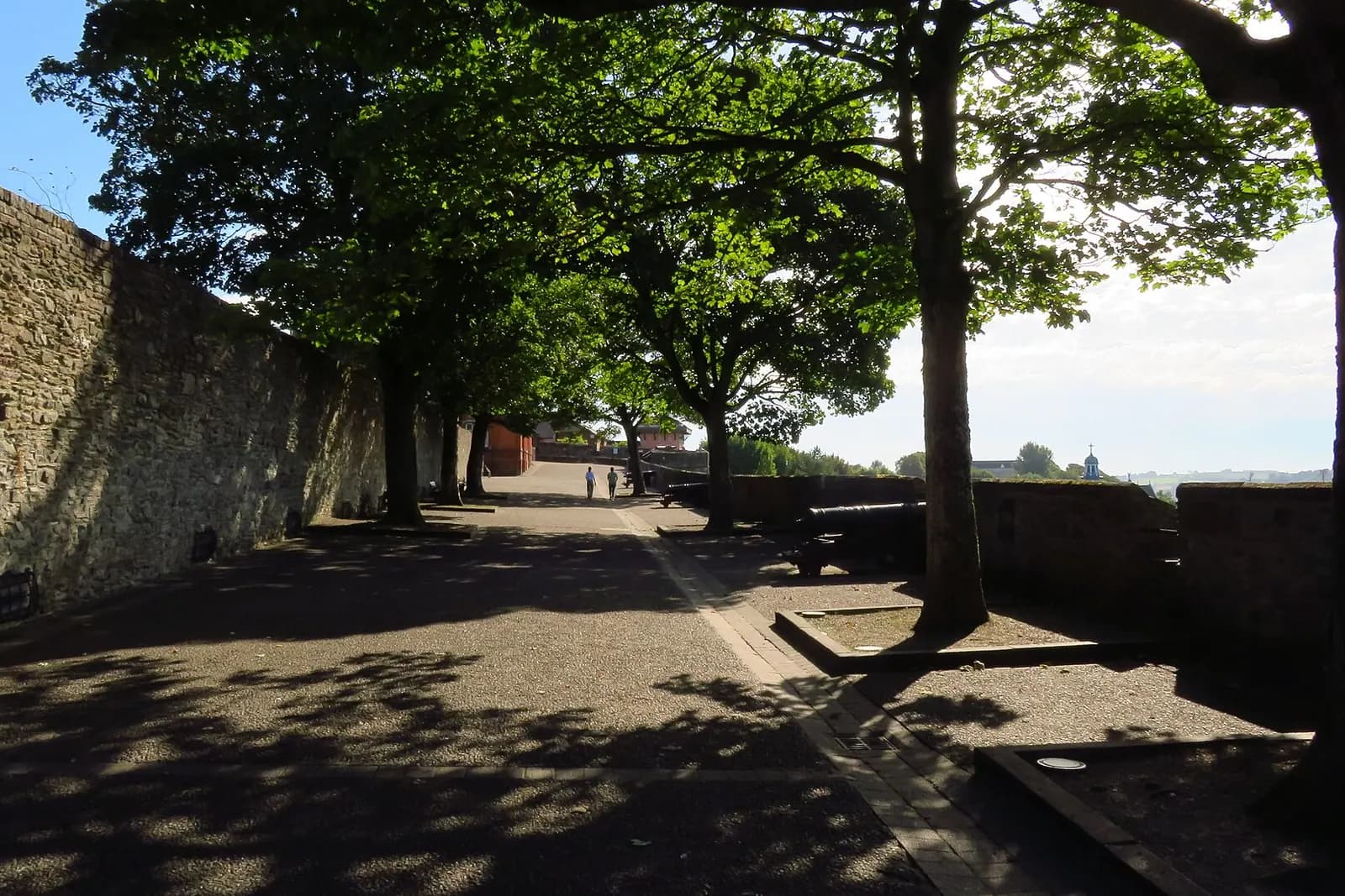 A tree-lined walkway along the top of Derry's old city walls