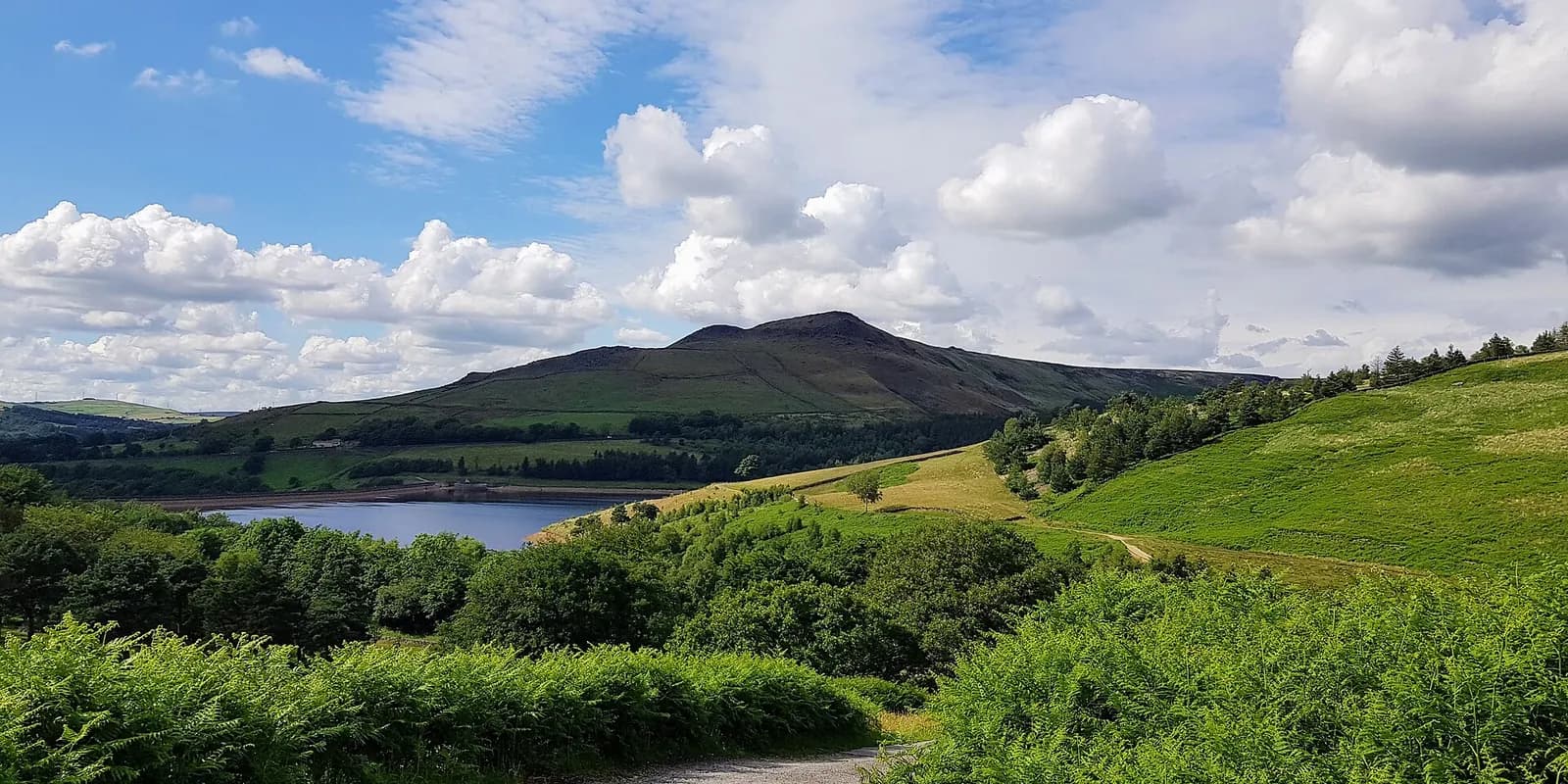 Dovestone Reservoir below green moorland hills on the edge of the Peak District