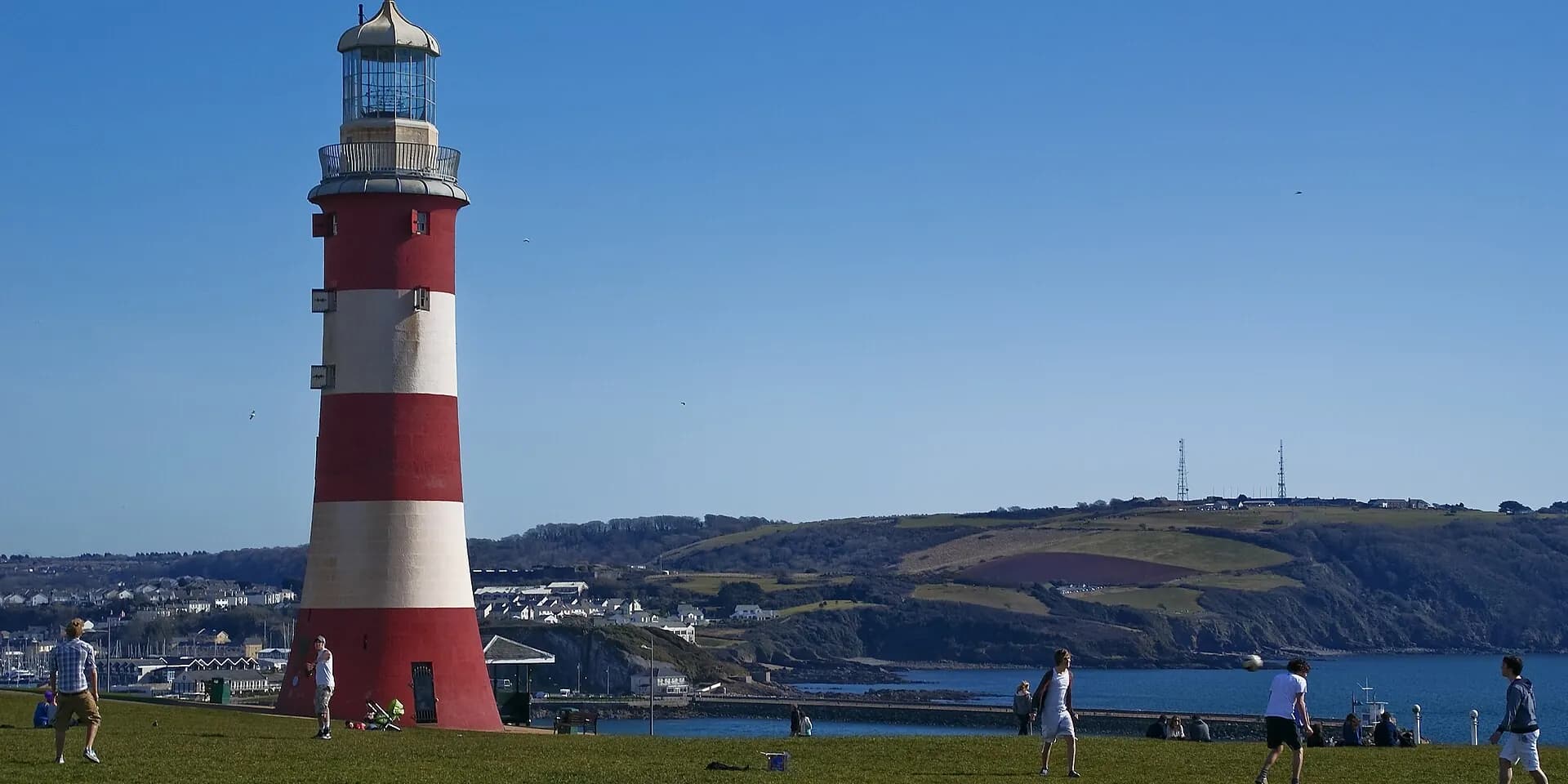 The red and white Smeaton's Tower lighthouse on Plymouth Hoe, with the Sound behind