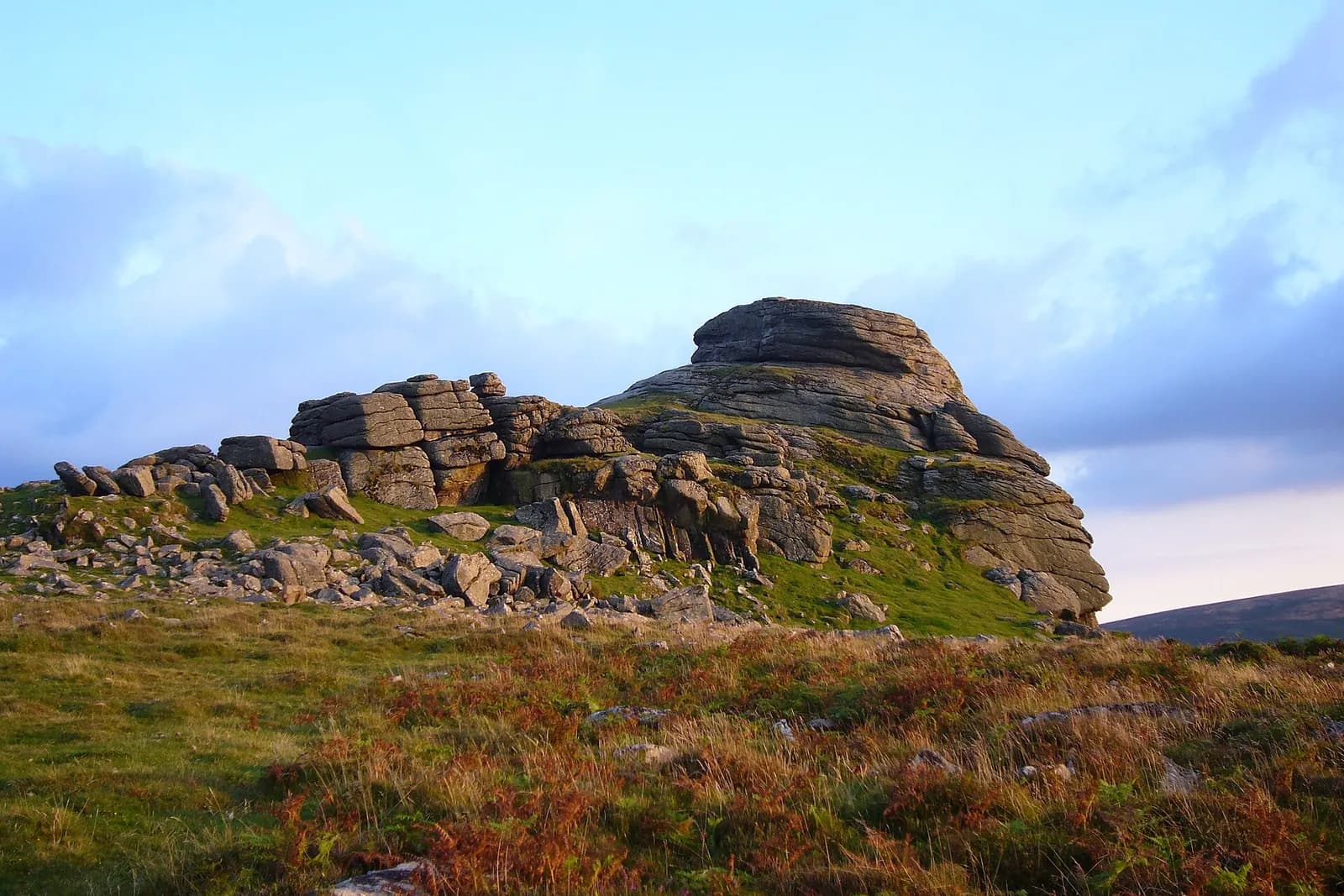 The granite outcrop of Haytor on Dartmoor in warm evening light, above moorland grass