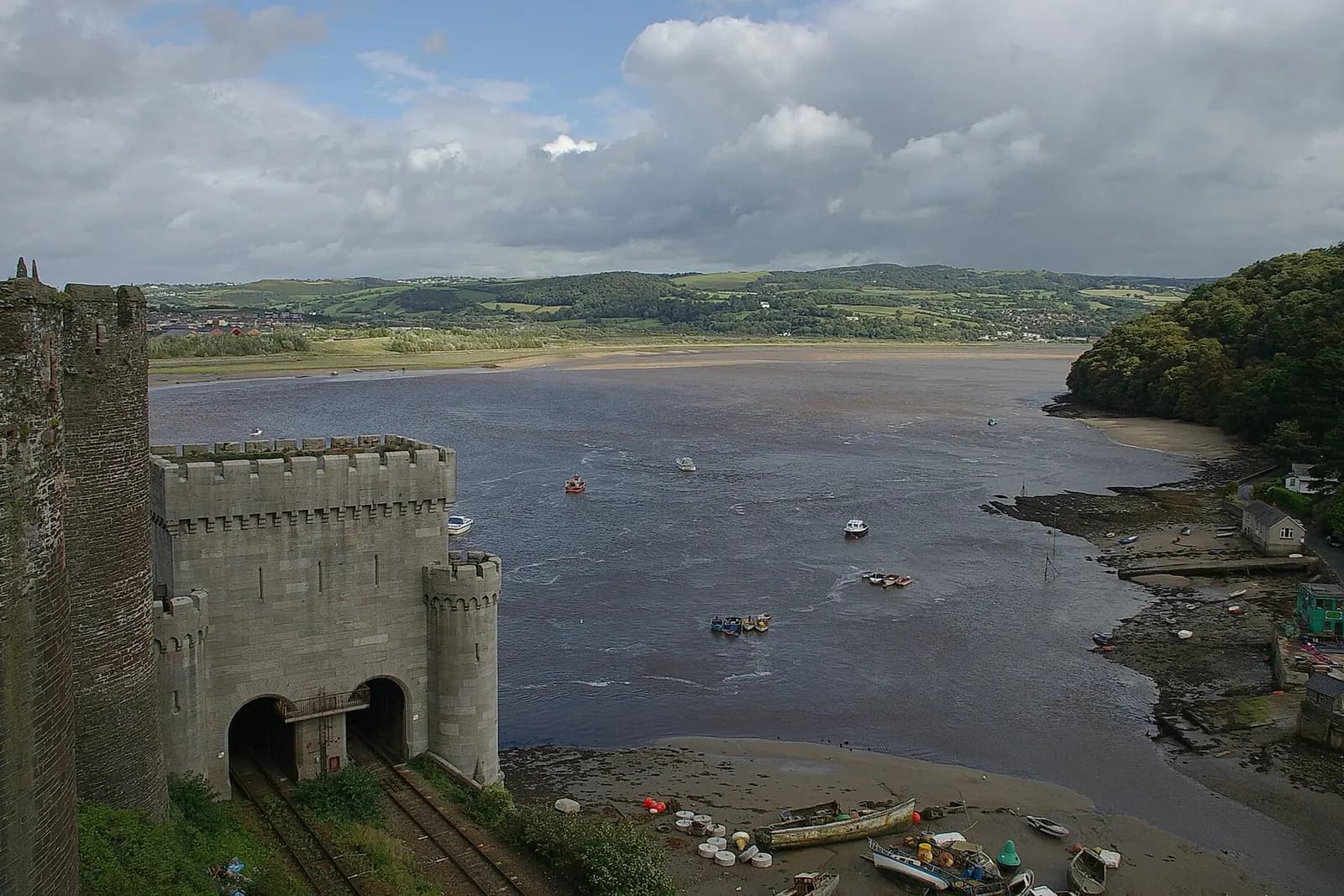 The Conwy estuary seen from a tower of Conwy Castle, with boats on the water and green hills beyond