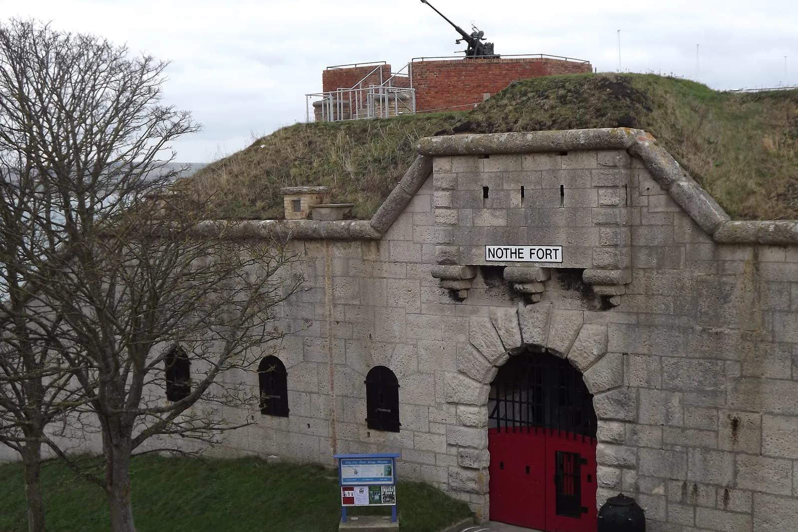 The arched stone gateway of Nothe Fort, a Victorian fort on its grassy mound