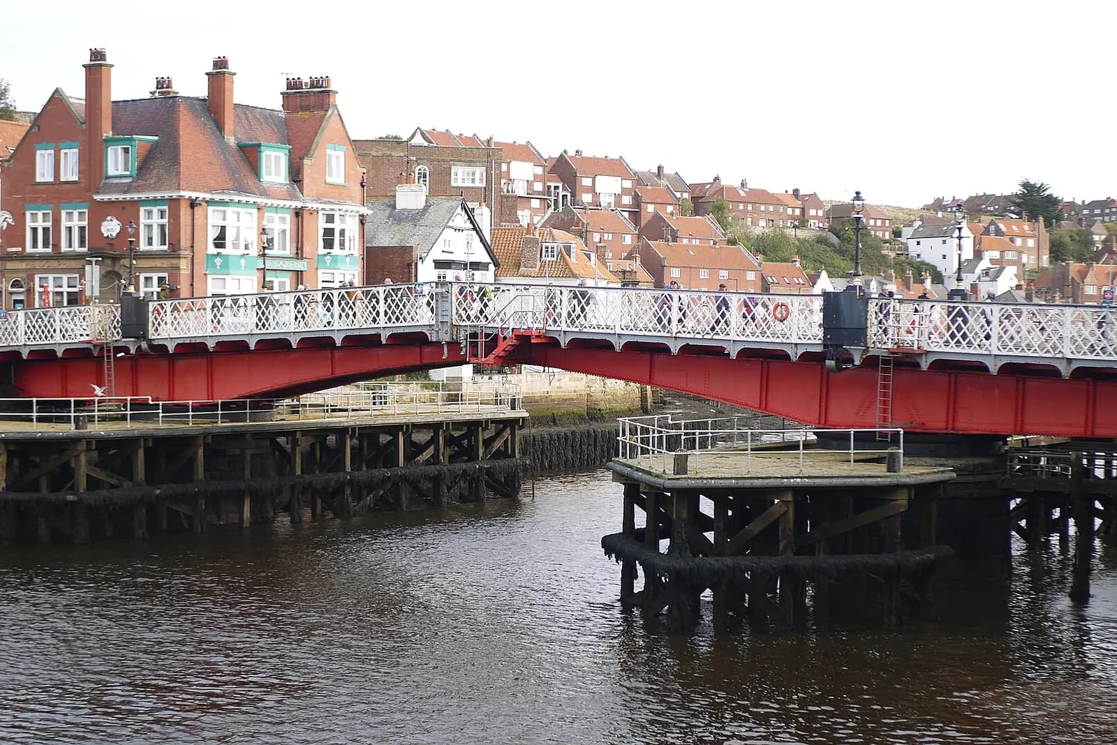 Whitby's red and white swing bridge over the River Esk, with the town's houses rising behind