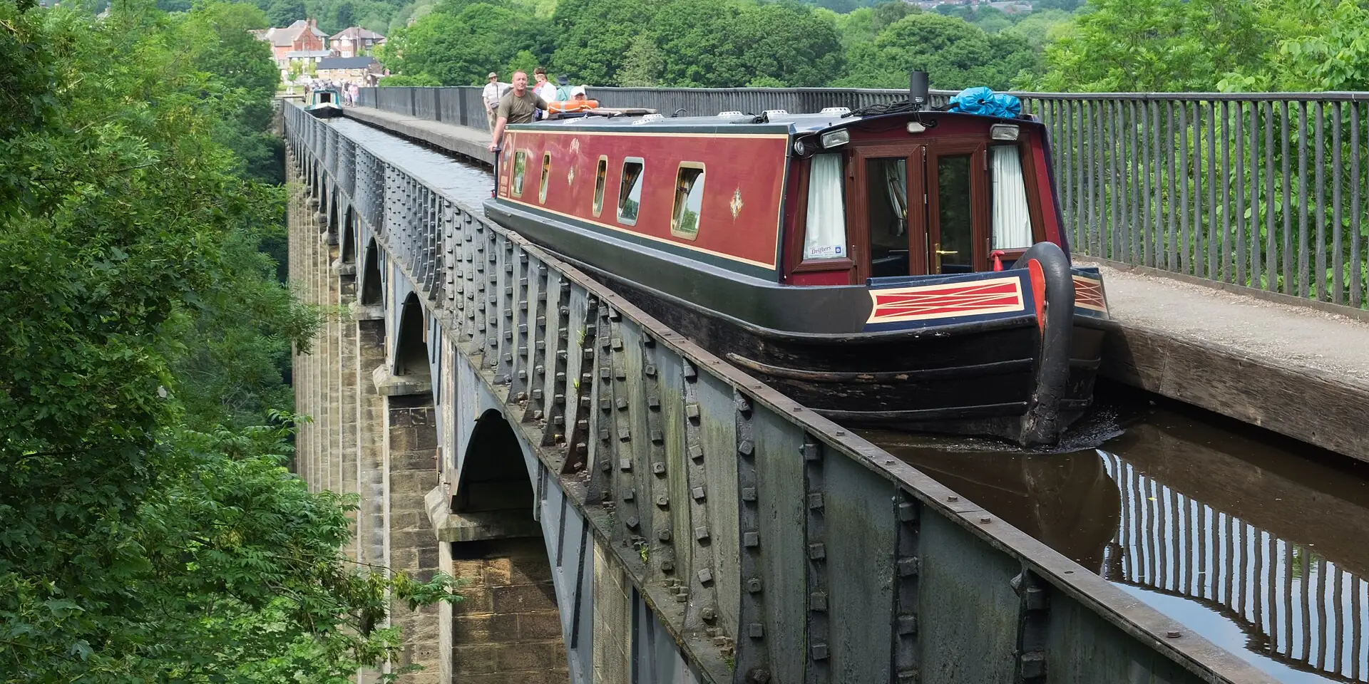 A narrowboat crossing the Pontcysyllte Aqueduct high above a wooded valley