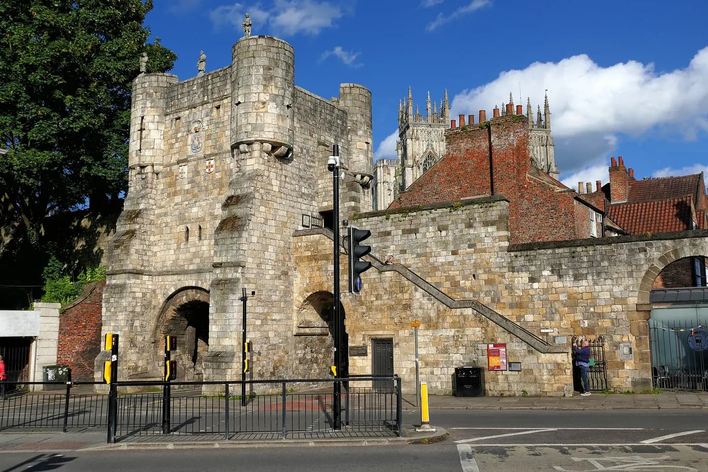 A medieval stone gatehouse in York's city walls, with the Minster's towers behind