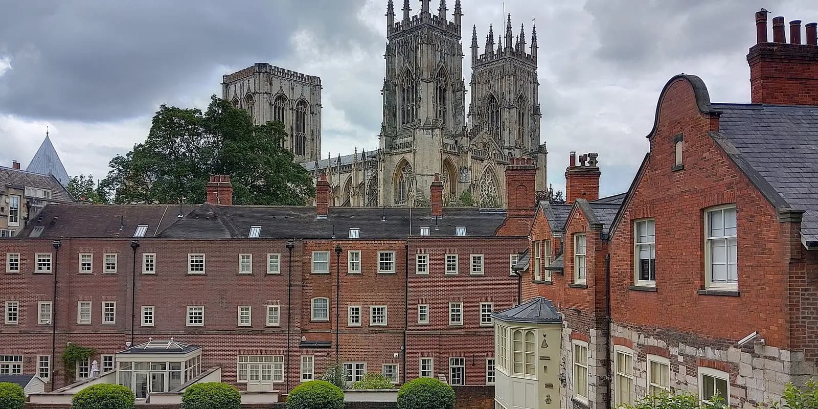 York Minster's towers rising above red-brick buildings, seen from the city walls
