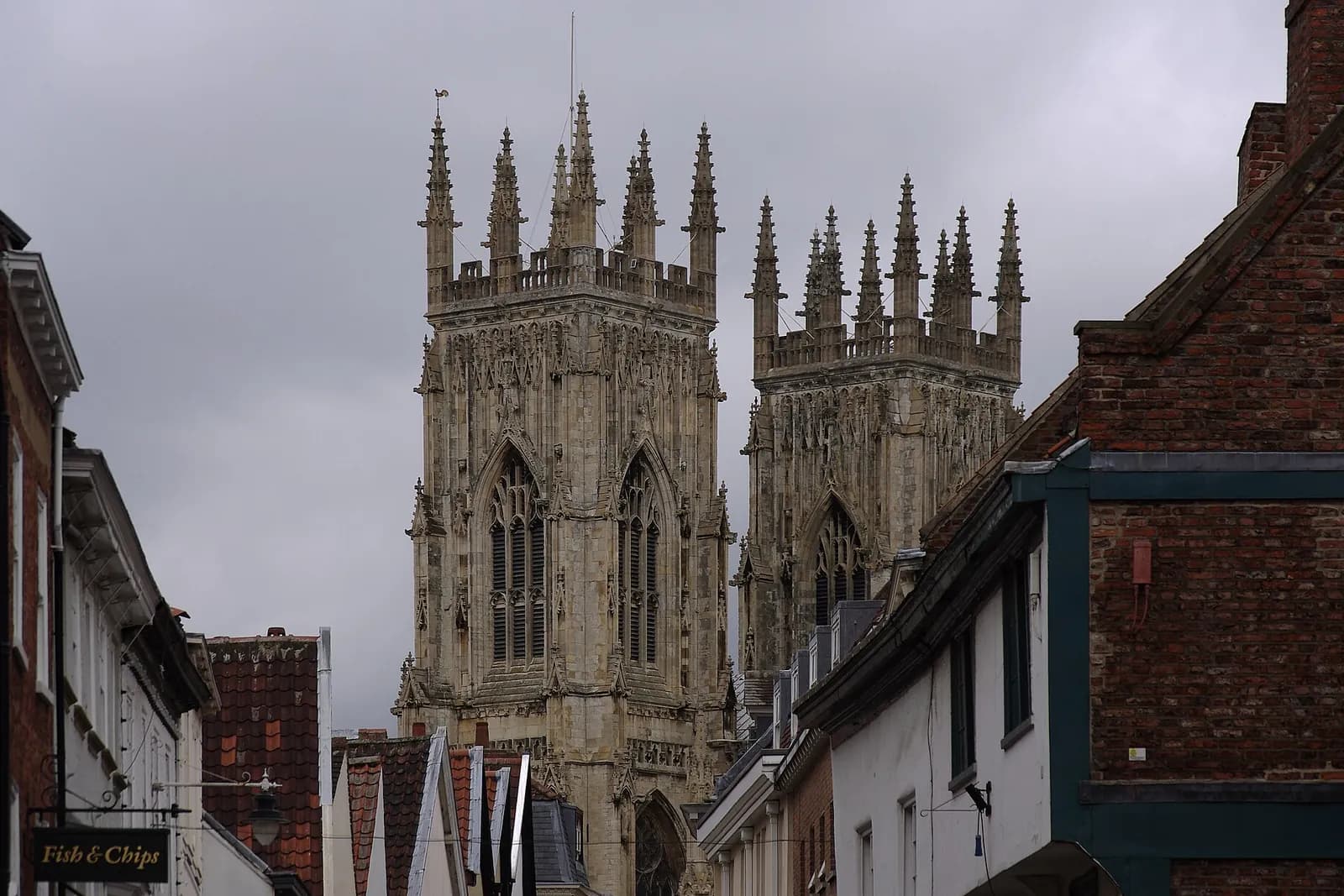 The towers of York Minster rising above old houses in a narrow York street