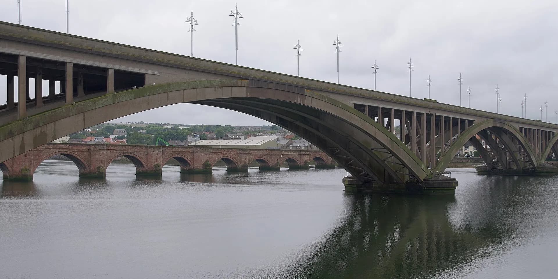 The concrete arches of the Royal Tweed Bridge over the River Tweed, with the old stone bridge behind
