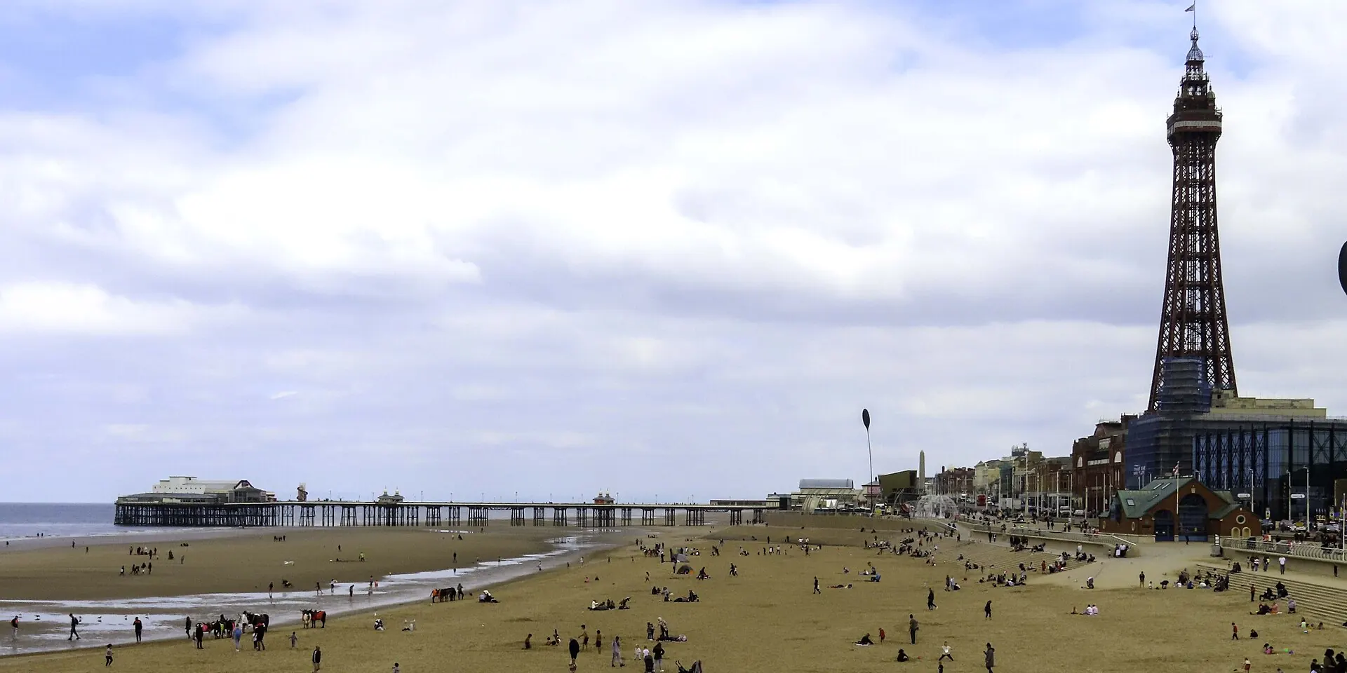 Blackpool beach at low tide, with the Tower and North Pier along the seafront