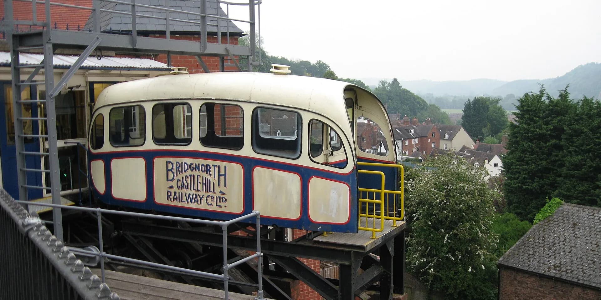 A carriage of the Bridgnorth Cliff Railway, with the town's rooftops and wooded hills behind