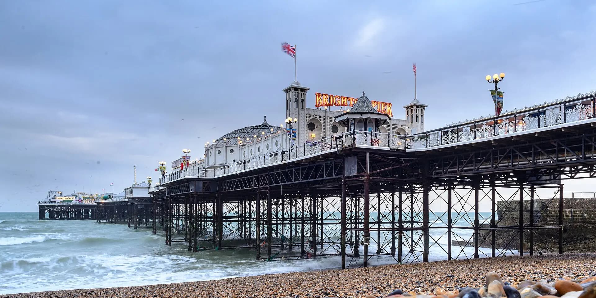 Brighton Palace Pier stretching out over the waves from the pebble beach