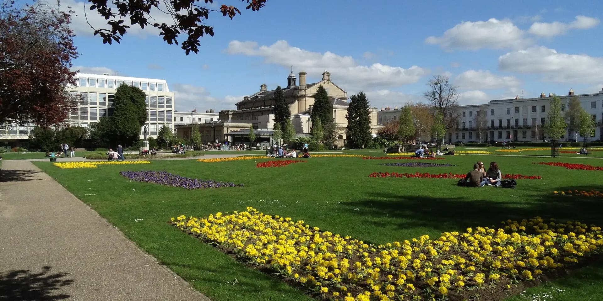 Flower beds and lawns in Cheltenham's Imperial Gardens, with Regency buildings beyond