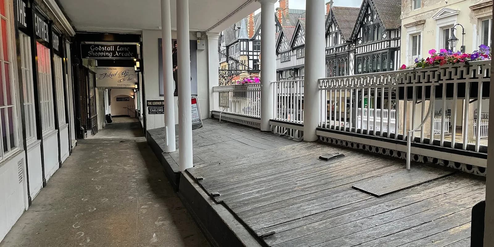 The covered walkway of the Chester Rows, with black-and-white timbered buildings across the street