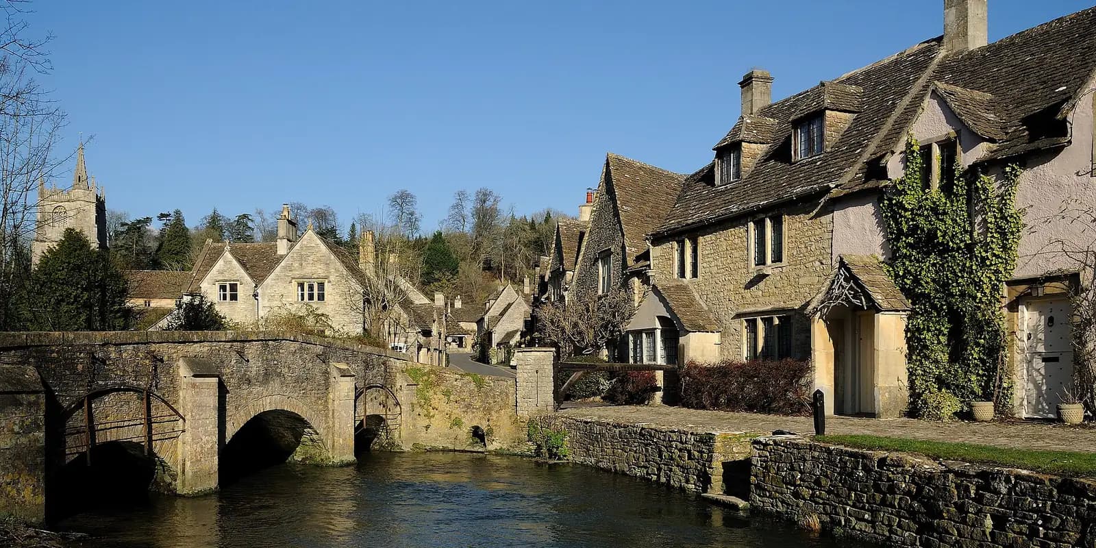 Honey-coloured stone cottages and an old stone bridge over the stream at Castle Combe