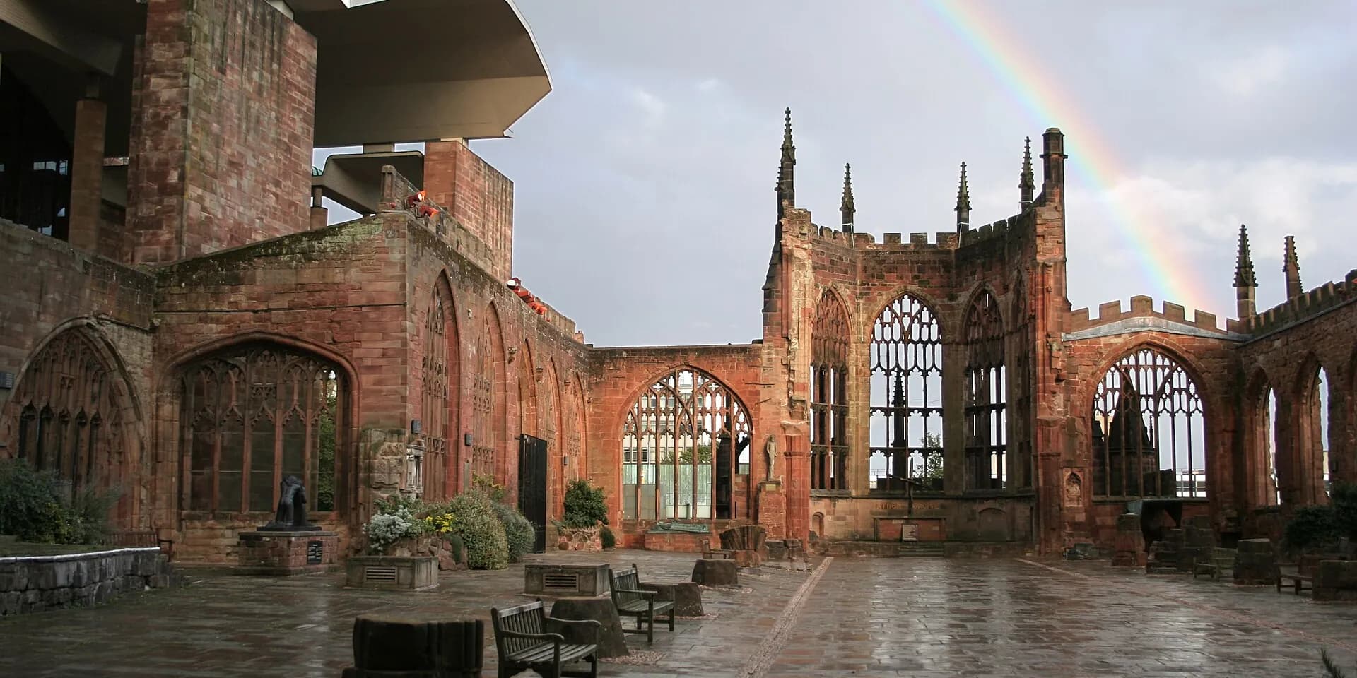 The red sandstone ruins of Coventry's old cathedral, with a rainbow in the sky above