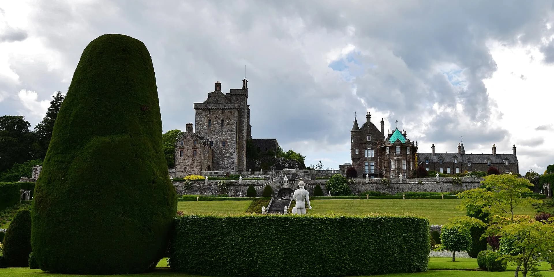 Clipped yew hedges and formal gardens below the stone towers of Drummond Castle
