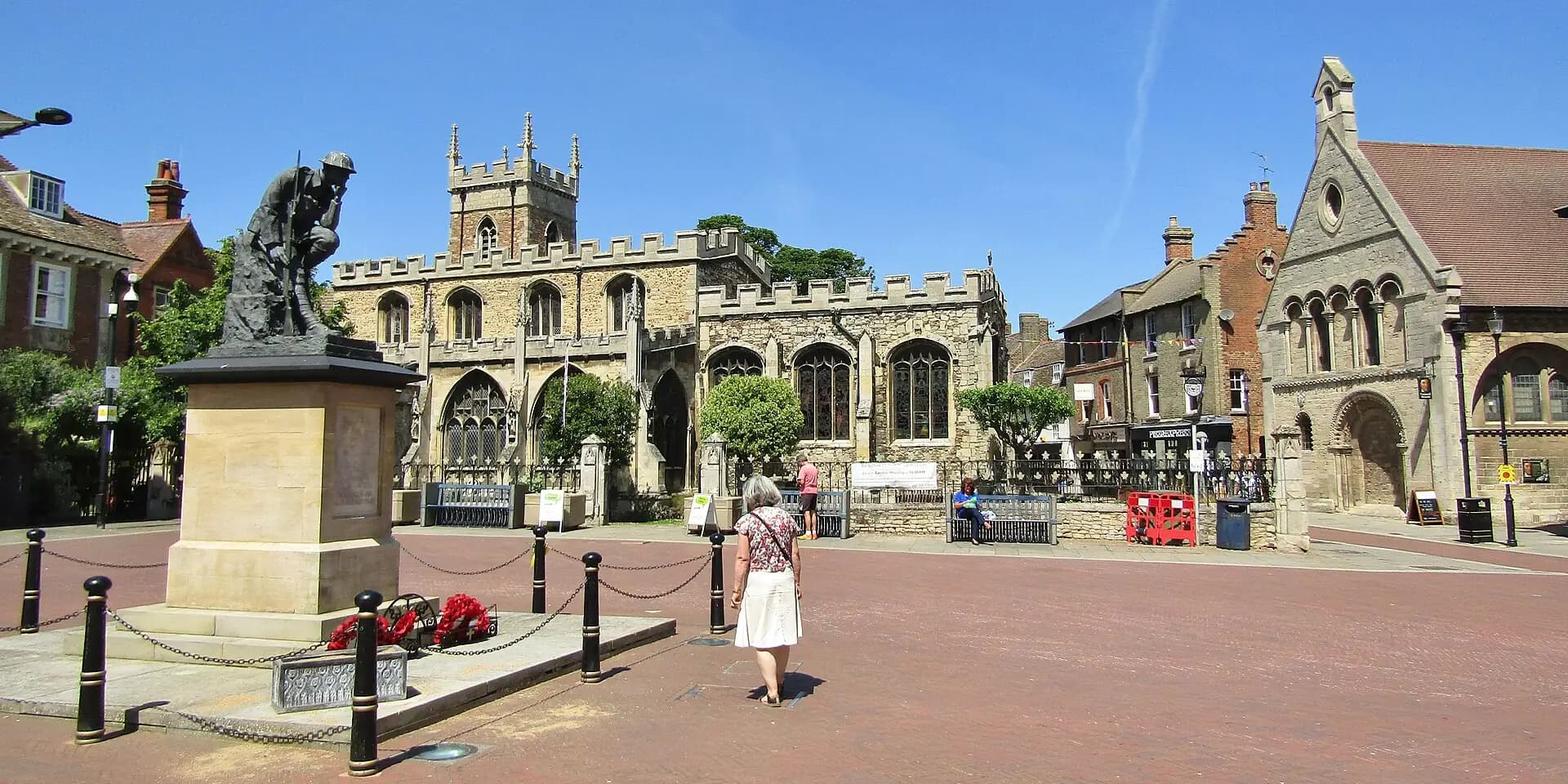 Huntingdon's town square with a war memorial statue, the parish church and old stone buildings