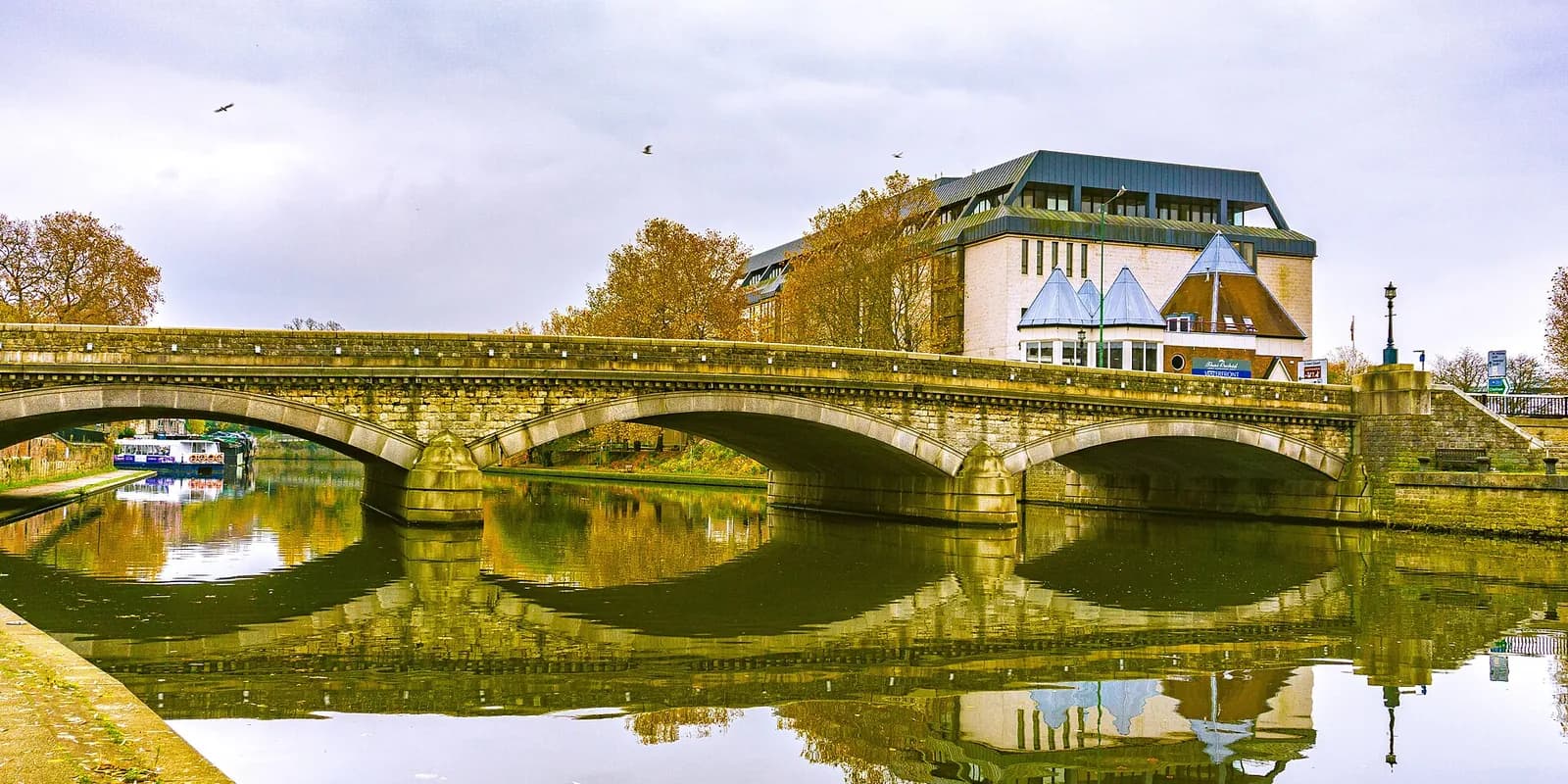 An old stone bridge over the River Medway in Maidstone, reflected in the still water