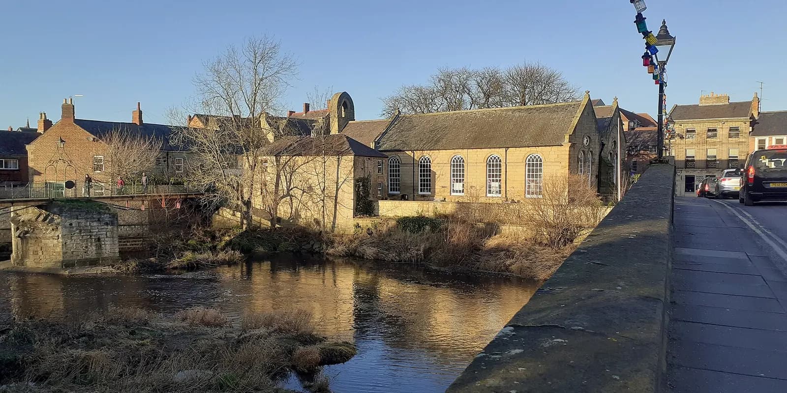 The River Wansbeck in Morpeth, with the old Chantry and stone buildings along the bank