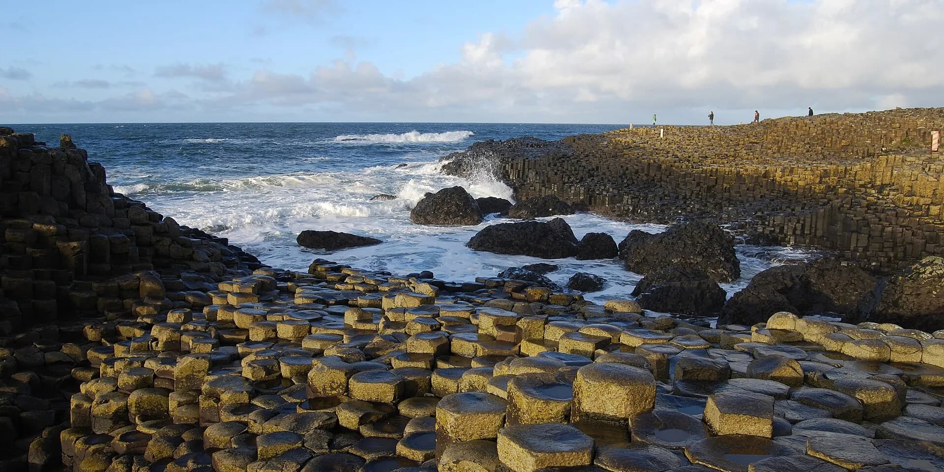 The six-sided basalt columns of the Giant's Causeway stepping down to the sea, with waves breaking beyond