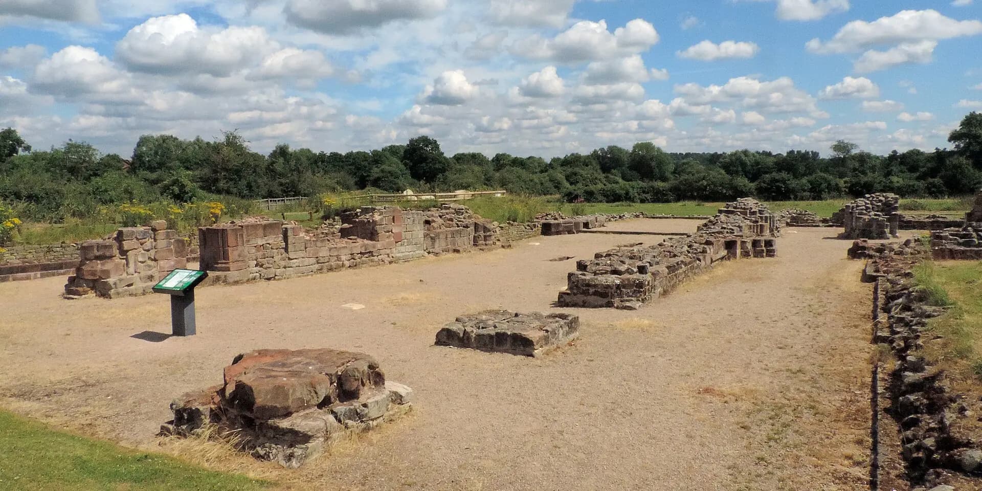 The low stone foundations of Bordesley Abbey's ruins on open grassland near Redditch