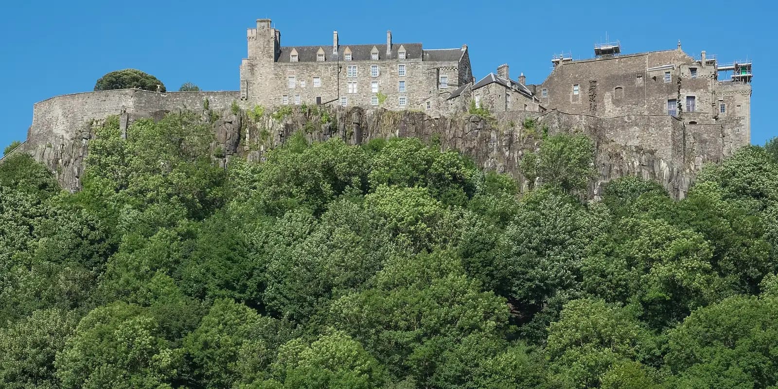 Stirling Castle on its rocky crag above a wooded slope