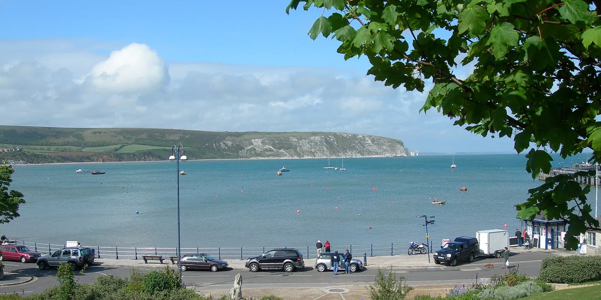 Swanage Bay's blue water and boats, with white cliffs on the far headland