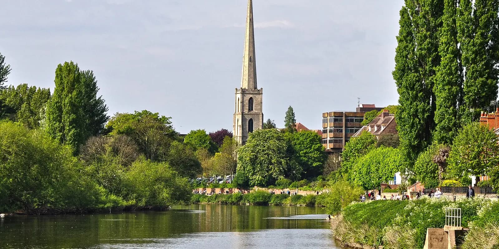 The River Severn at Worcester, with trees along the bank and a church spire rising above